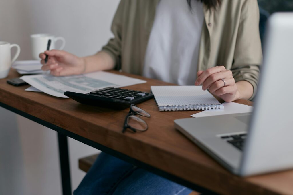 Woman working at a desk, reviewing a website privacy policy on a laptop while taking notes.