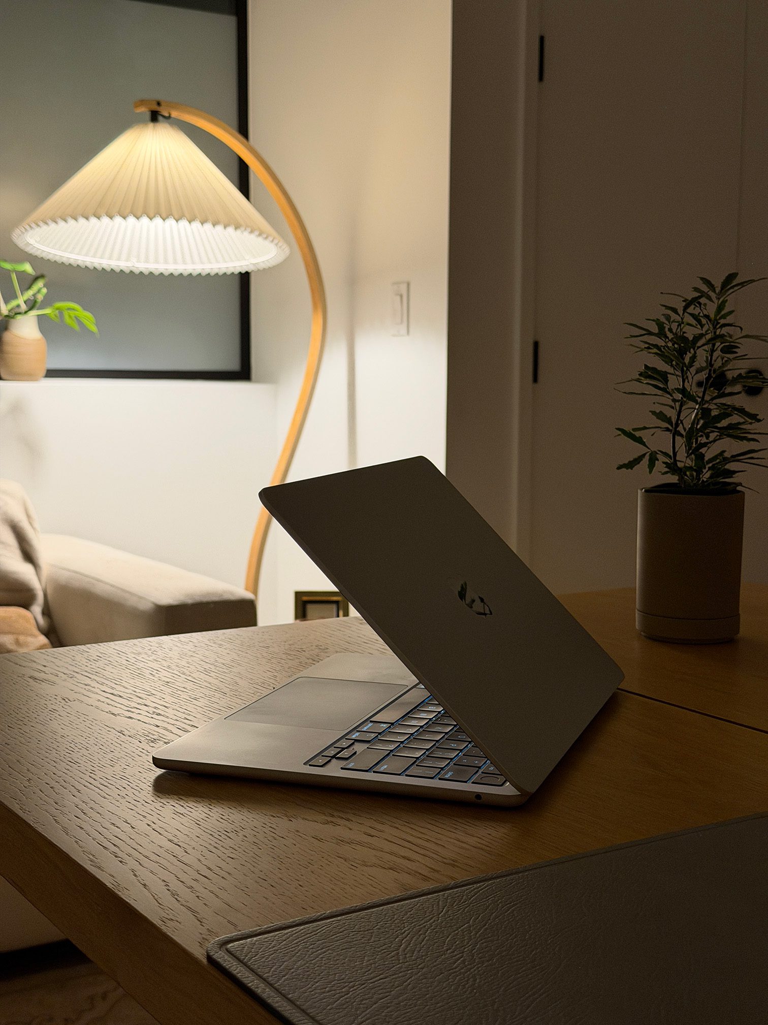 A laptop placed on a wooden table in a well-lit room, showcasing a modern workspace setup.