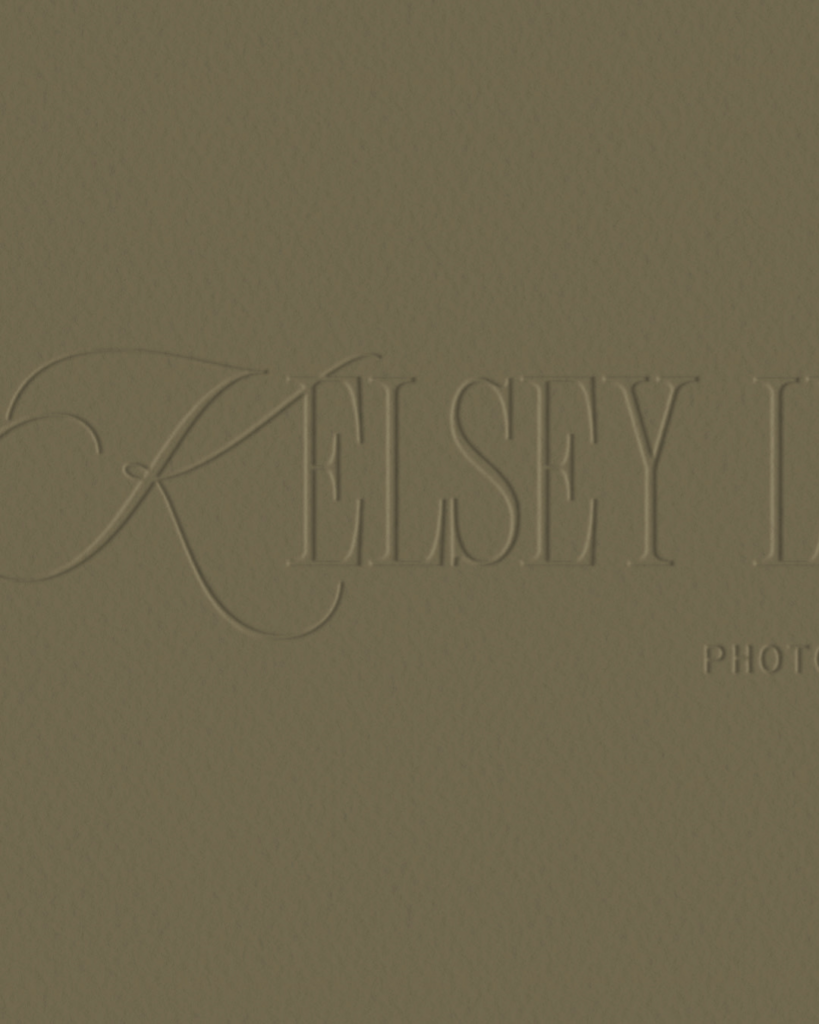 Muted olive-gray logo graphic with faint, oversized embossed serif lettering reading “KELSEY H…” and smaller “PHOT…” text at lower right, creating a subtle, understated tone.