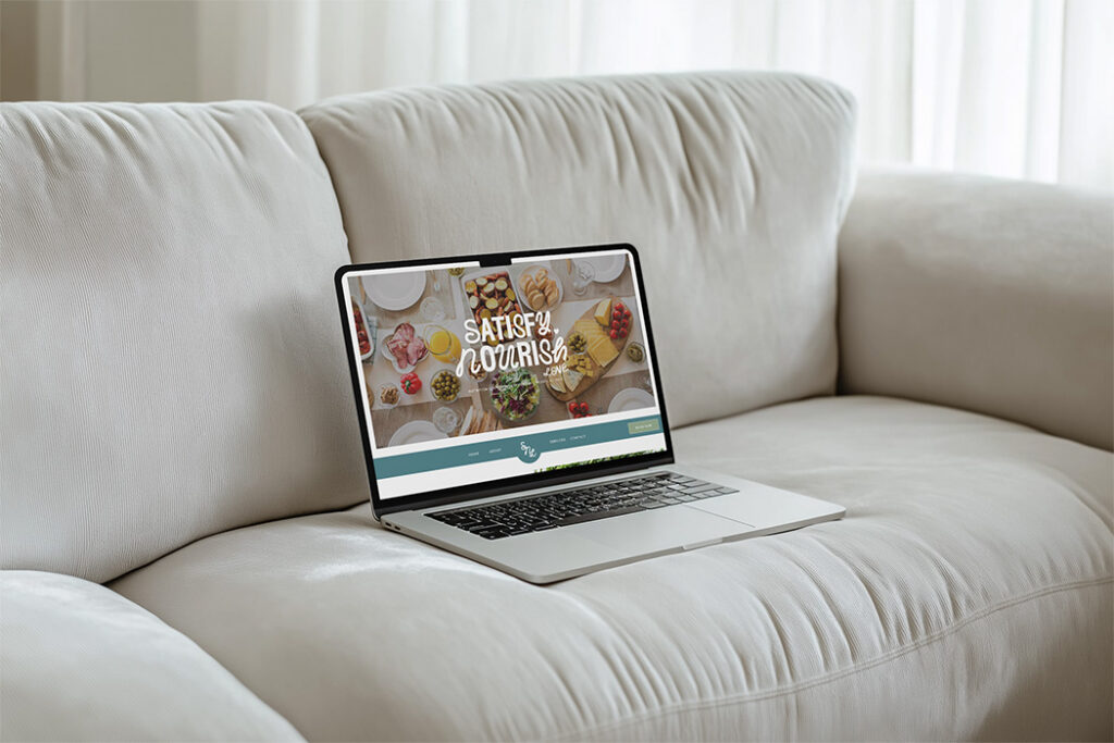 Laptop displaying a colorful “Satisfy Your Curiosity” website rests on a plush white sofa in a bright, cozy living room, conveying calm.