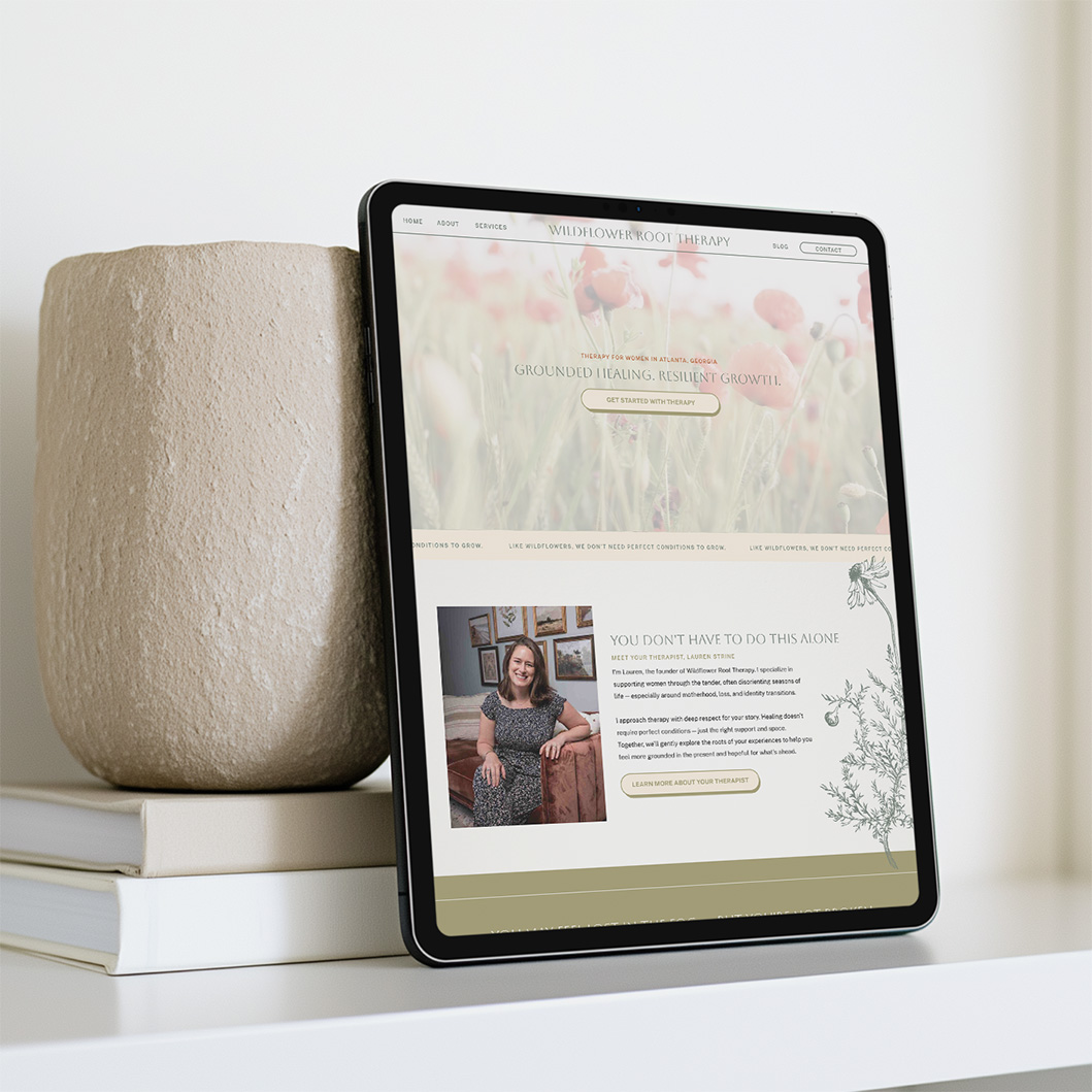 Tablet displaying a soft floral wellness website beside a textured vase and stacked books, creating a calm, welcoming atmosphere.
