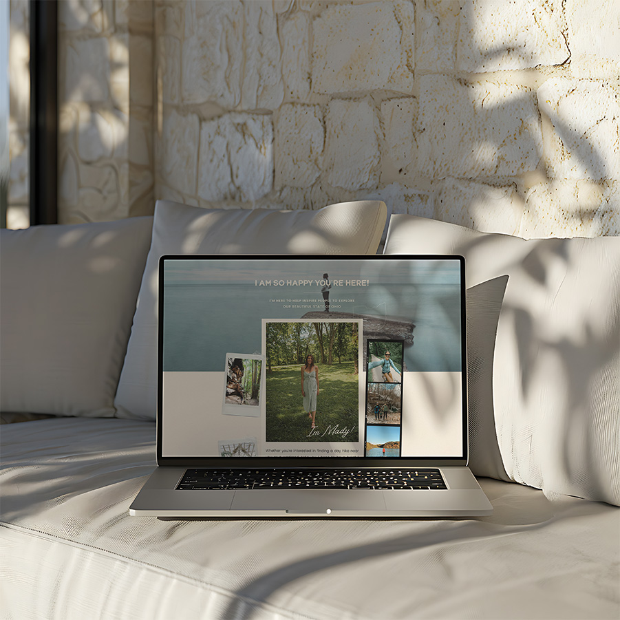 Open laptop displaying a travel photography portfolio on a sunlit white daybed, framed by textured stone walls and soft shadows; calm, inviting mood.