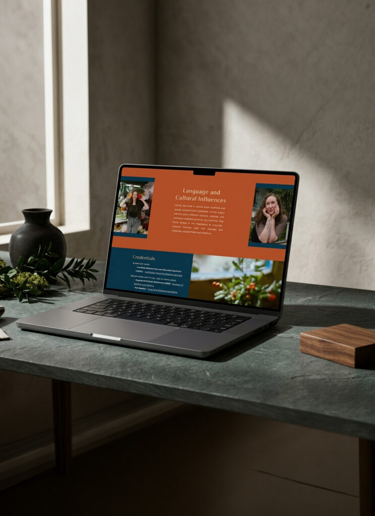Laptop displaying a warm, modern culture and lifestyle webpage with portraits and flowers, set on a dark desk beside a vase.