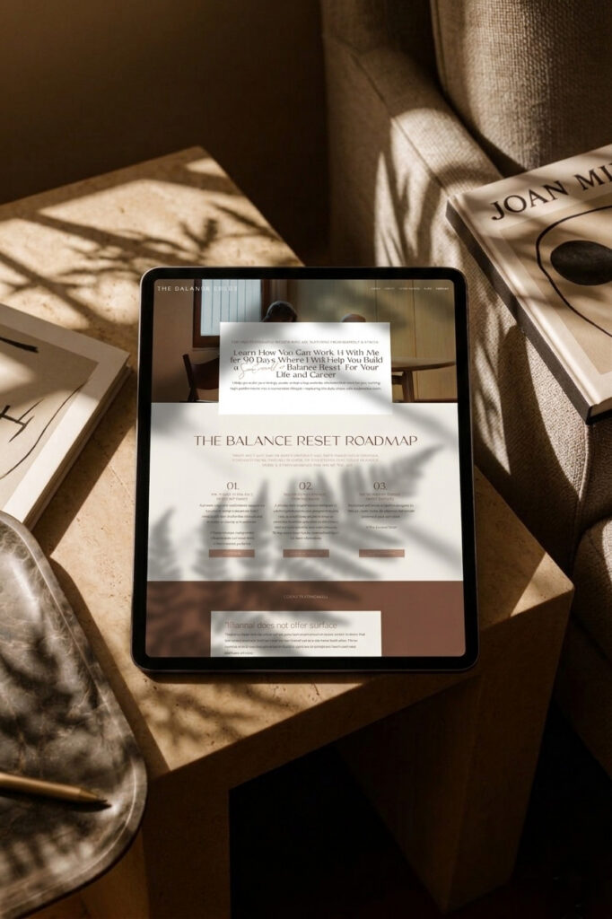 A tablet displays “The Balance Reset Roadmap” on a sunlit wooden table, beside books and a linen chair; warm shadows create a calm, reflective mood.