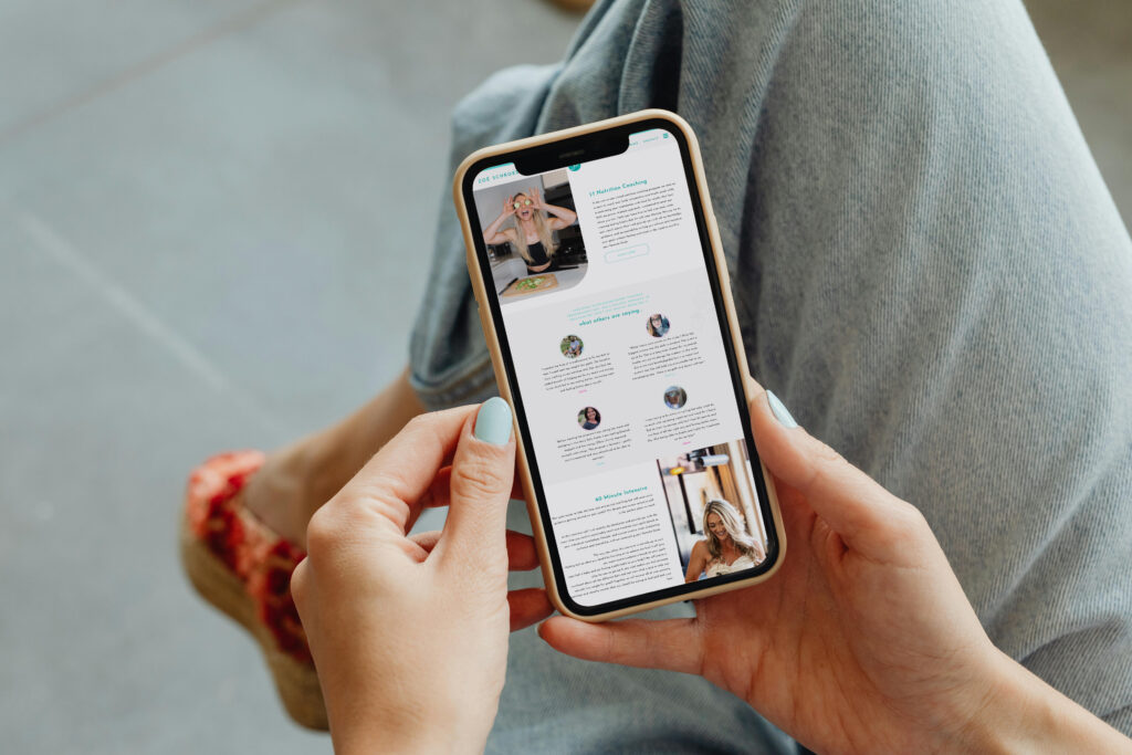 Close-up of hands holding a smartphone displaying a social media feed, with a person in jeans and red shoes seated casually in the background.