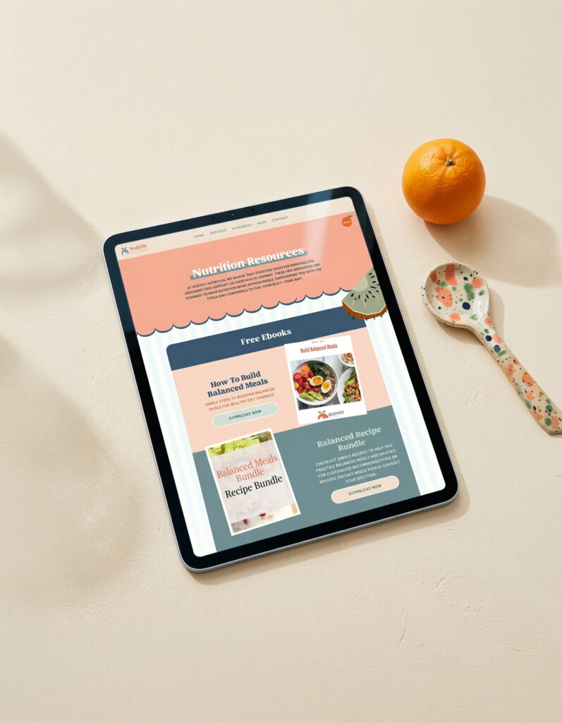 Tablet displays a cheerful nutrition resources webpage with healthy recipes and balanced meal guides, beside an orange and floral spoon.