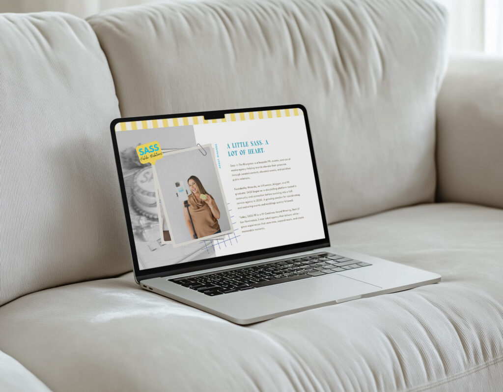 A laptop displaying a SASS magazine article rests on a plush white sofa in a bright, quiet living room, creating a calm, relaxed mood.