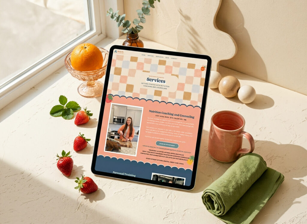 Sunlit still life with a tablet displaying a “Services” webpage, strawberries, orange, tea mug, rolled green towel, and eucalyptus.