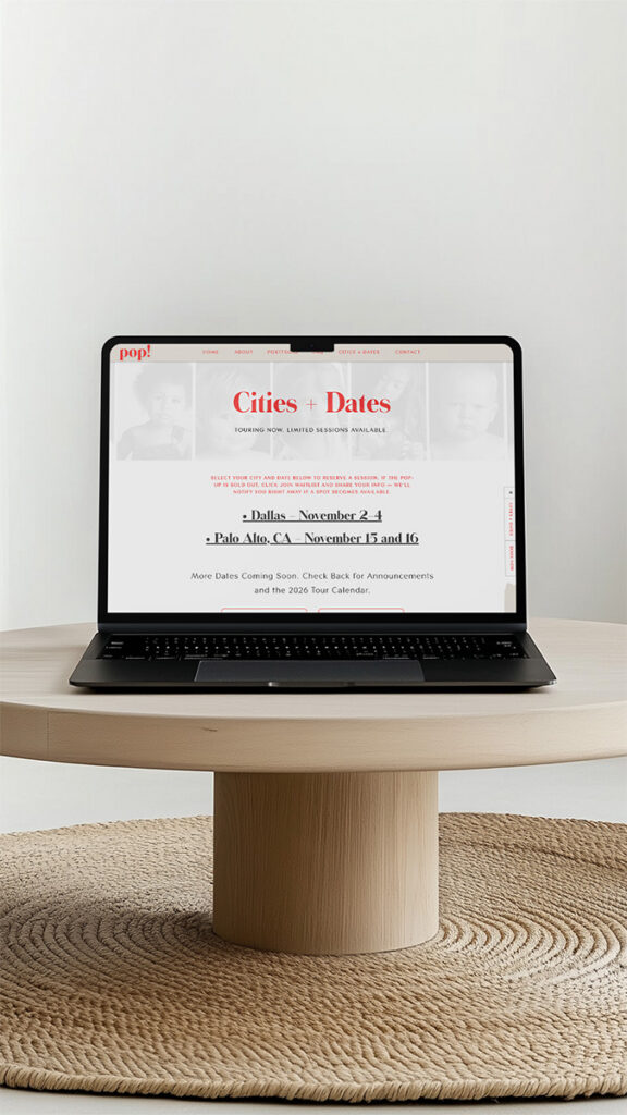 A black laptop displays a vintage-style “Cities + Dates” webpage on a round wooden table, creating a calm, minimalist home-office scene.