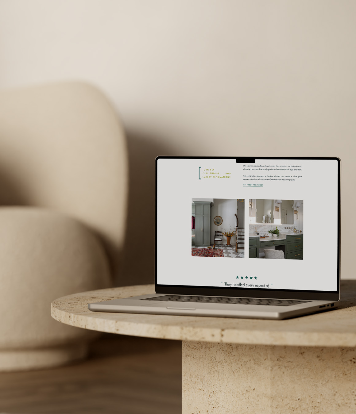 Laptop displaying a home décor webpage with room photos and review stars, resting on a round stone table beside a beige sofa in warm light.