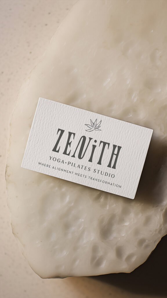 White “Zenith Yoga Pilates Studio” business card on a textured cream surface, conveying a calm, minimalist wellness aesthetic.