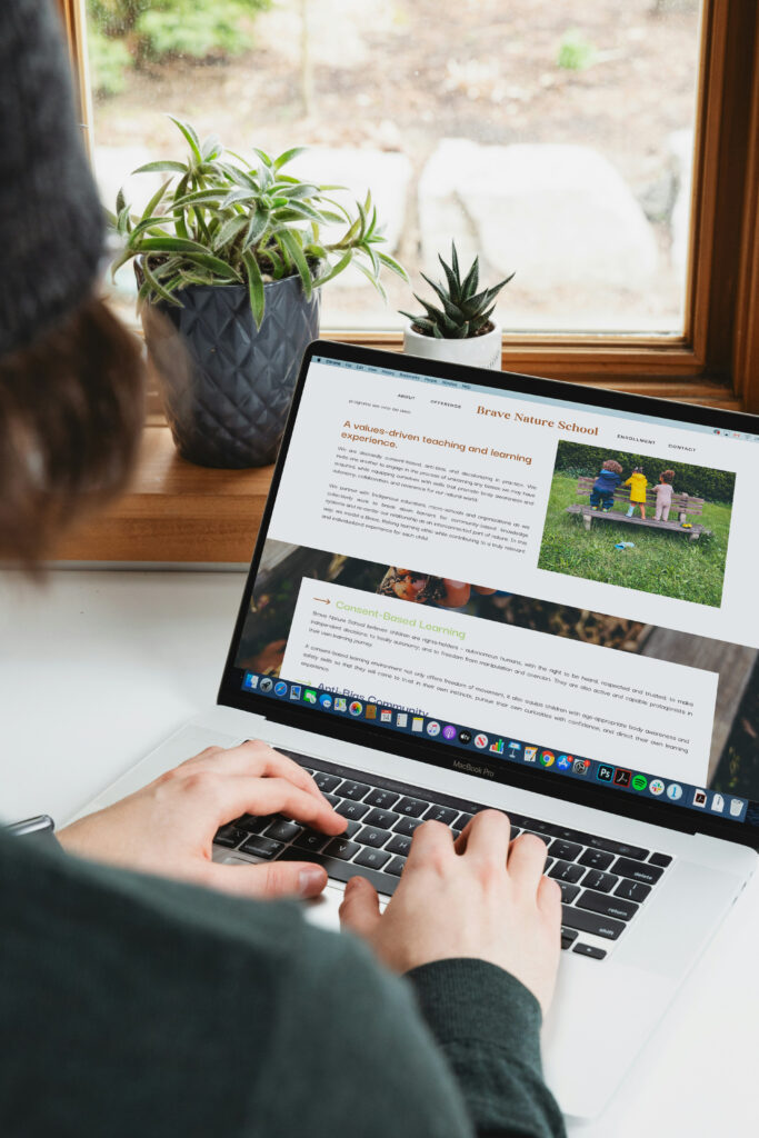 A person types on a laptop displaying a gardening article, with potted plants on a sunny windowsill; the scene feels calm and focused.