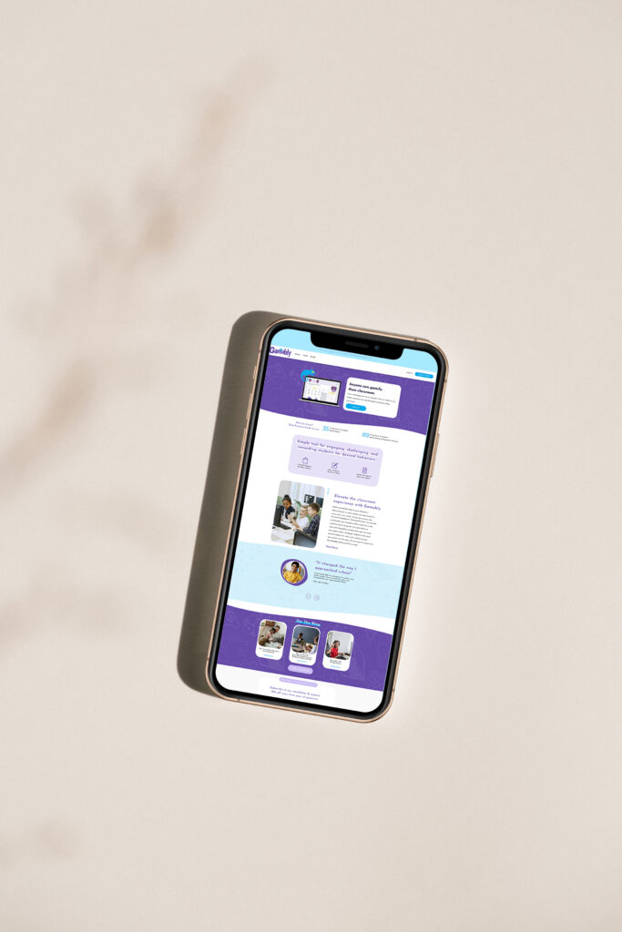 A smartphone lies at an angle on a soft beige surface, displaying a bright purple-and-white ed tech website with text and thumbnail images; the scene feels calm and minimal.