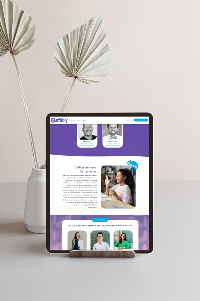 An iPad displays a purple-and-white Grably website featuring people and text, on a minimalist table beside a vase with dried palm leaves. Calm, modern setting.