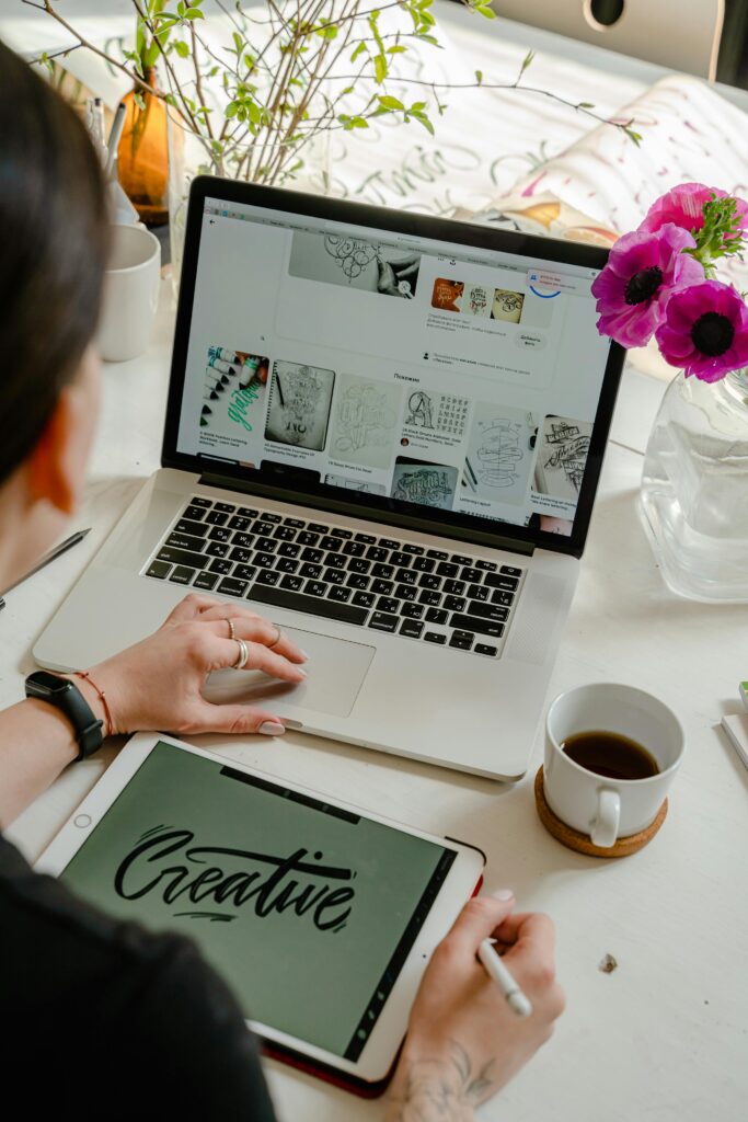 Woman planning content on a laptop and iPad, organizing ideas for a health and wellness website.